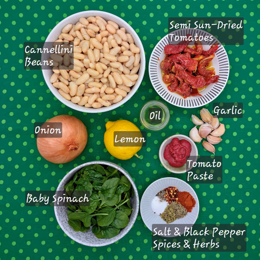 Labelled Ingredients for Marry Me Beans recipe. Oil, onion, garlic, tomato paste, dried herbs, chilli flakes, smoked paprika, cannellini beans, semi-dried tomatoes, lemon juice, baby spinach.
